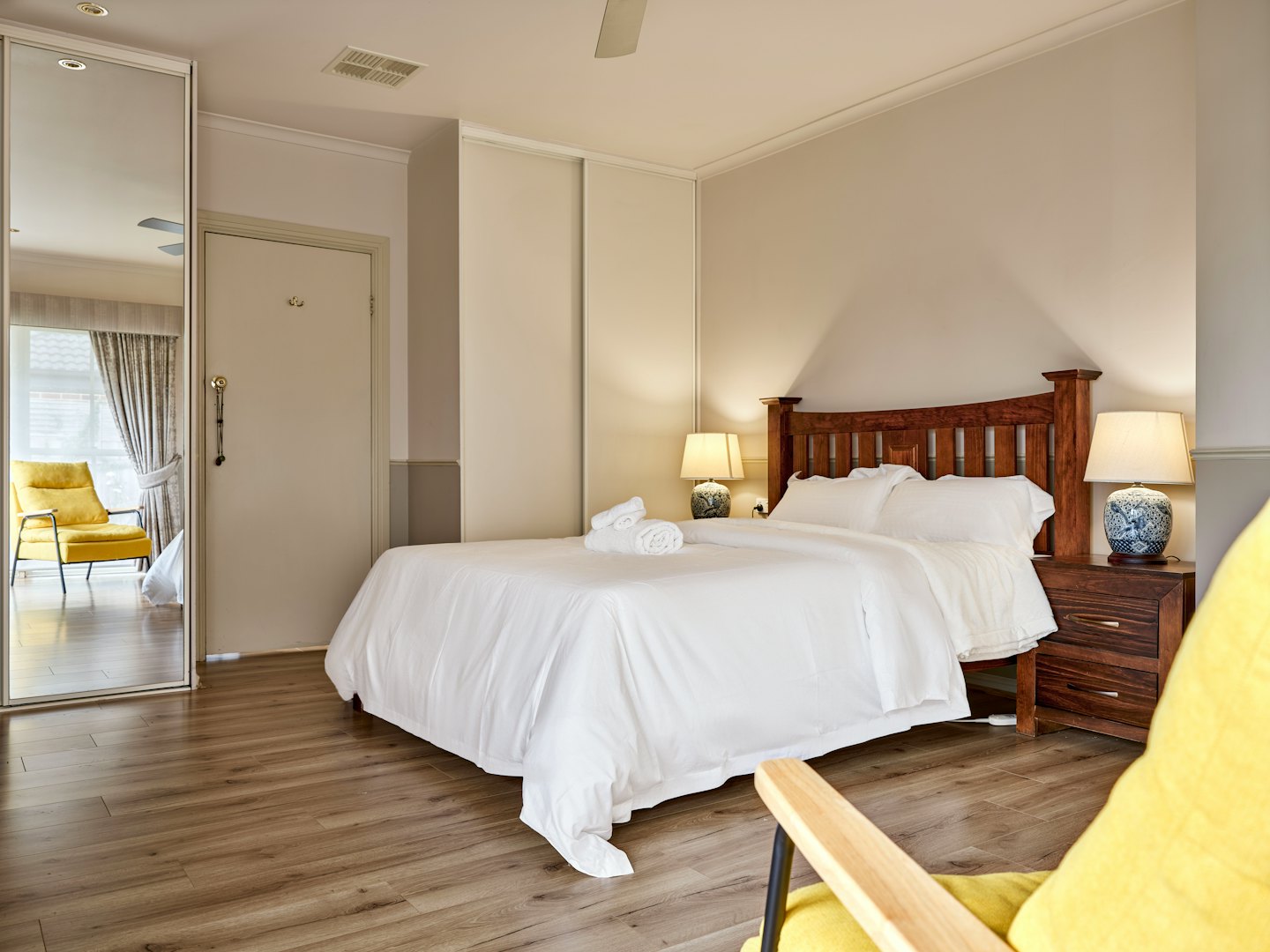 Contemporary bedroom with wooden furniture and blue patterned lamps.